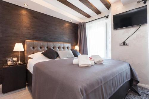 a bedroom with a large bed with two towels on it at Apartments Regent 2 in Rovinj