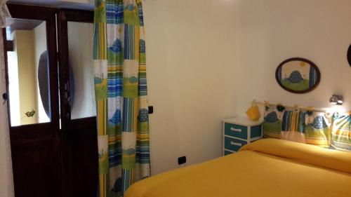 a bedroom with a yellow bed and a window at casa di campagna dal pozzo in Sorso