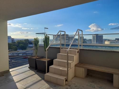 a balcony with stairs and a view of a city at City Sanctuary in Windhoek