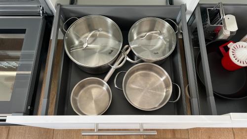 a bunch of pots and pans in a drawer at Apartment Hof Düker, 2 Komfort DZ, Design Bad in Gütersloh