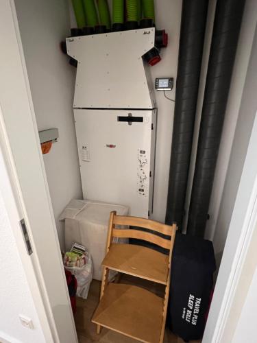 a chair in a small room with a refrigerator at Apartment Hof Düker, 2 Komfort DZ, Design Bad in Gütersloh