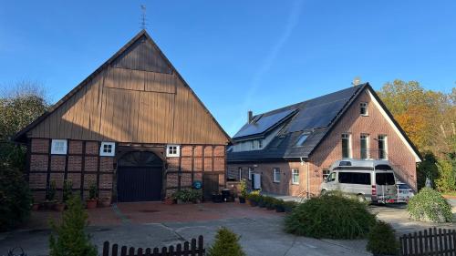 a large barn with a van parked in a driveway at Apartment Hof Düker, 2 Komfort DZ, Design Bad in Gütersloh