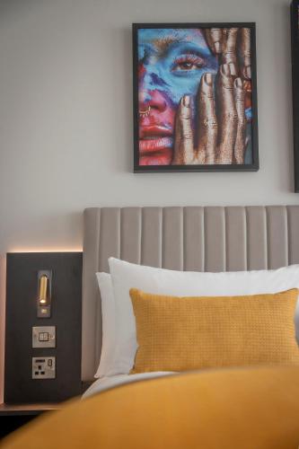 a bedroom with a bed and a painting on the wall at Maldron Hotel Shoreditch London in London