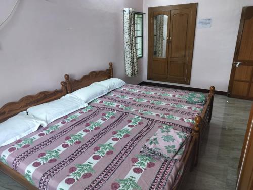 a bed in a room with a bedspread on it at Honeycomb Homestay Ground Floor in Palni