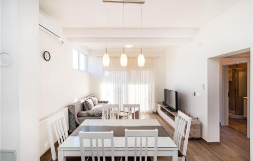 a dining room and living room with a table and chairs at Cozy Home In Posedarje With Wifi in Posedarje