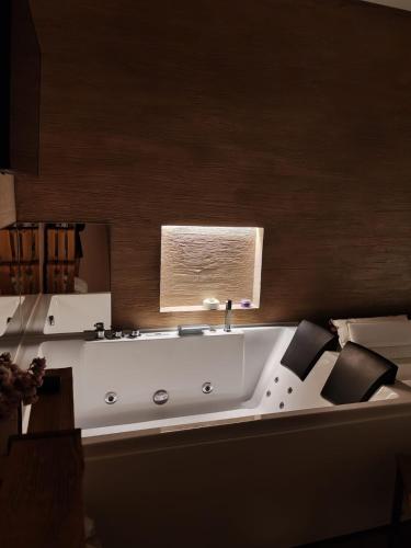 a bathroom with a white bath tub with a window at Dimora Fajano in Fasano
