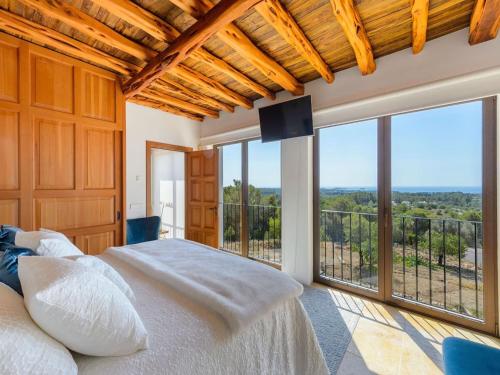 a bedroom with a large bed and a large window at Holiday home with children play area in Santa Eularia des Riu