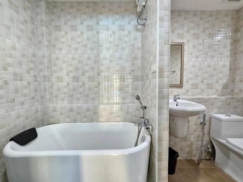 a bathroom with a white tub and a sink at CottagePine Rayong Resort&Cafe in Ban Ko Kloi