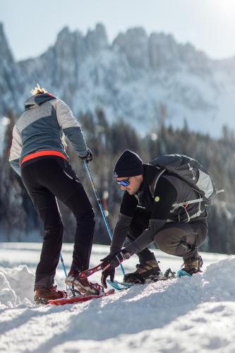 two people on skis in the snow at Moseralm Dolomiti Spa Resort in Nova Levante