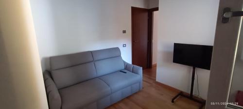 un salon avec un canapé bleu et une télévision dans l'établissement Un angolo a Milano..., à Milan