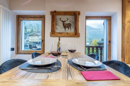 a wooden table with two glasses of wine on it at HelloCHALET - Casa Val - Your Walking Distance holiday in Valtournenche