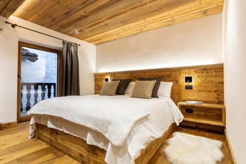 a bedroom with a large bed and a window at HelloCHALET - Casa Val - Your Walking Distance holiday in Valtournenche