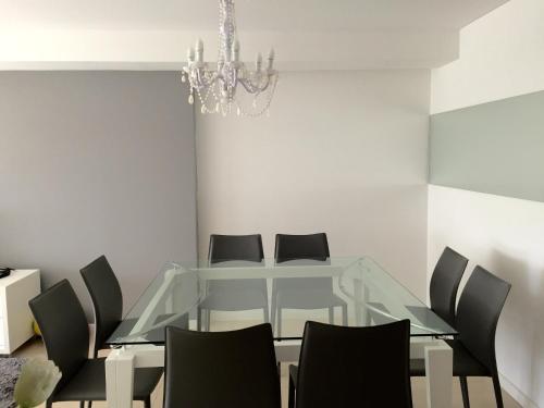 una sala da pranzo con tavolo e sedie in vetro di Torre del mar a Punta del Este