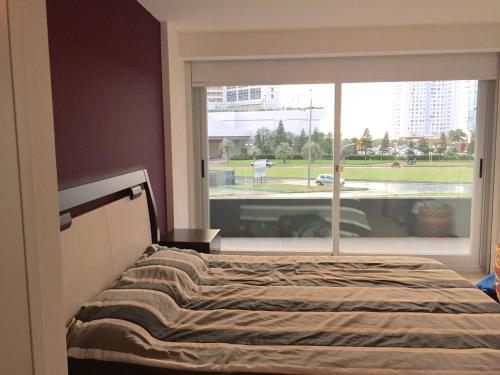 1 dormitorio con cama y ventana grande en Torre del mar, en Punta del Este