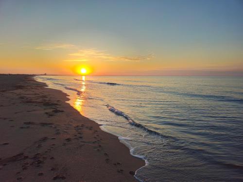 a sunset on a beach with the ocean at L'étape méditerranéenne logement 4-6 personnes avec parking privé in Sauvian