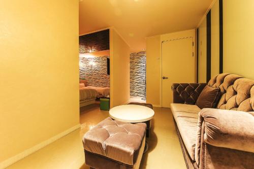 a living room with a couch and a table at The Oreun Echae Hotel in Jeju