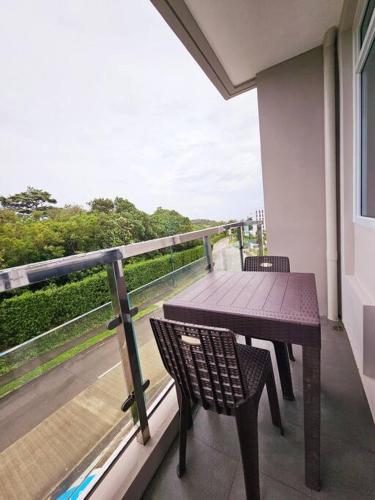 a balcony with a wooden table and chairs on a balcony at Evelyn's Azure Escapes at Boracay Newcoast in Boracay