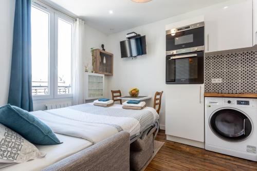 une chambre avec un lit avec une laveuse et une sécheuse dans l'établissement Cosy 2 PIECES CHAMPS-ÉLYSÉES-DEFENSE, à Puteaux