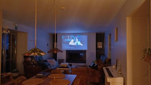a living room with a tv on the wall at La Colline aux Fées in Yvoir