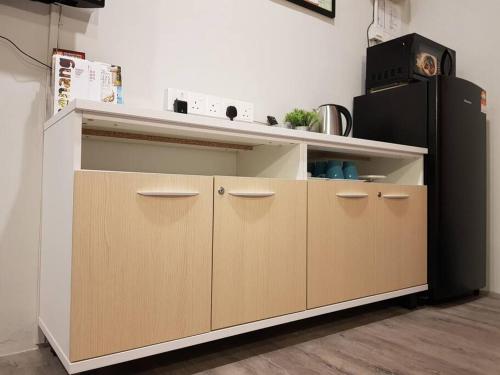 a kitchen with brown cabinets and a black refrigerator at Heritage Studio in UNESCO Zone near to StreetArt & Town 1 in George Town