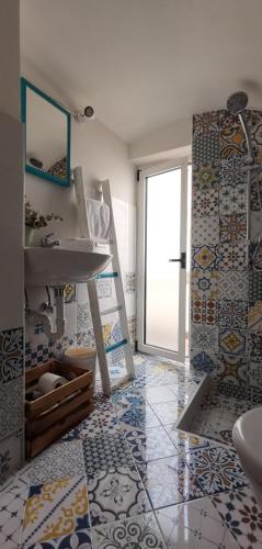 a bathroom with a sink and a tile floor at MI PUGLIA Casa vacanze in Putignano