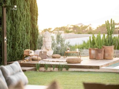a garden with a statue and a table and chairs at Villa in Ibiza near Cala Conta Beach in Cala Comte