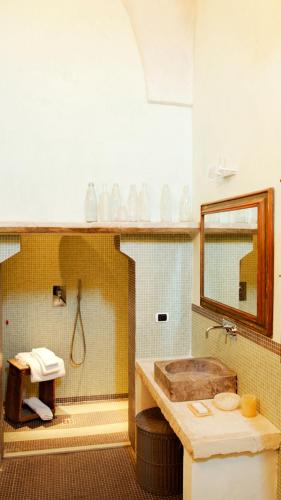 a bathroom with a tub and a sink and a mirror at Wp RELAIS LOCANDA FIORE DI ZAGARA in Diso
