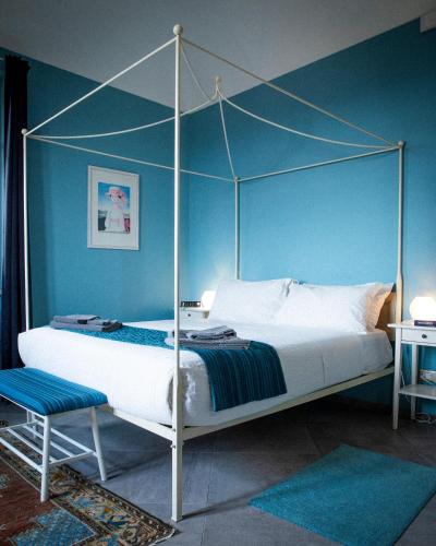 a bedroom with a canopy bed with a blue wall at VILLA ADRIANA in Bra