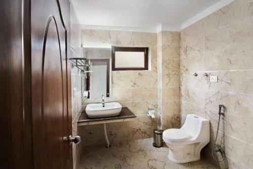 a bathroom with a sink and a toilet and a mirror at Hotel Ladakh Marvel Leh in Leh