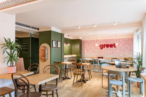 a restaurant with tables and chairs and a sign that says great at greet Hôtel Prévessin Genève Aéroport in Prévessin