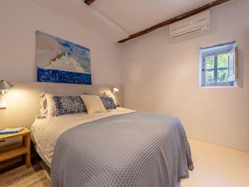 a white bedroom with a bed and a window at Farmhouse in Ibiza with Saltwater Pool in Puig D’en Valls