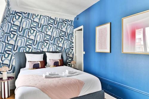- une chambre bleue avec un lit et 2 serviettes dans l'établissement Appartement Paisible Centre de Paris - Bleu - II, à Paris