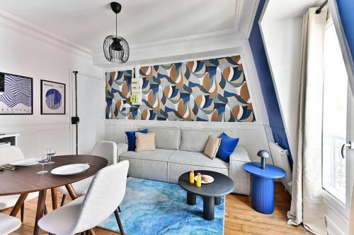 un salon avec un canapé et une table dans l'établissement Appartement Paisible Centre de Paris - Bleu - II, à Paris