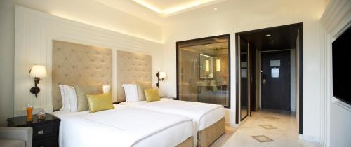 a bedroom with two white beds in a room at Taj Ganges Varanasi in Varanasi