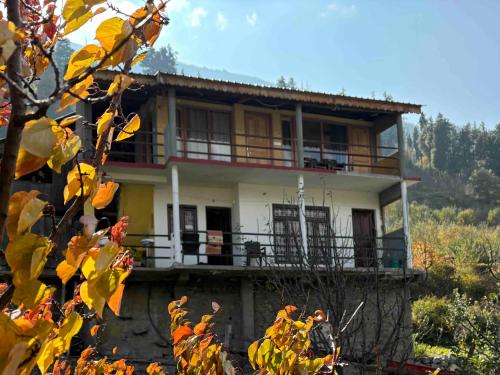 a house with a balcony on a hill at Majestic Heights Homestay in Harsil