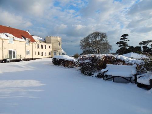 a snow covered yard in front of a house at Kingswear Park Club with Swimming Pool & Spa in Kingswear