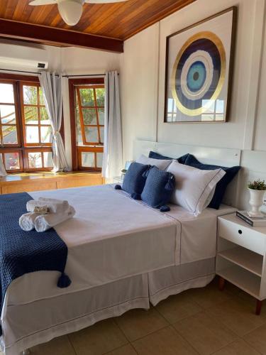 a bedroom with a large bed with blue and white pillows at Chalé das Águas in Igaratá