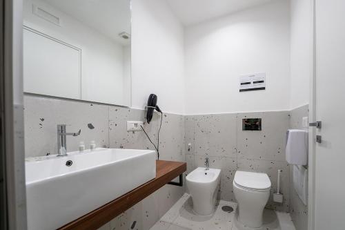 a white bathroom with a sink and a toilet at Mia Suites Hotel Bella Capri in Naples