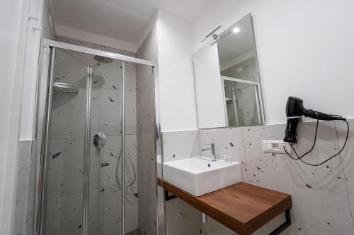 a bathroom with a sink and a shower at Mia Suites Hotel Bella Capri in Naples