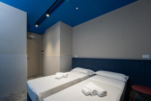 a bedroom with two beds with towels on them at Mia Suites Hotel Bella Capri in Naples