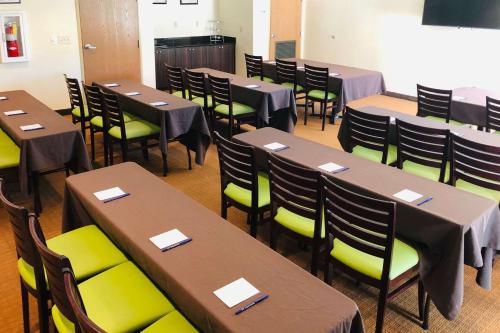 a dining room with tables and green chairs at Sleep Inn & Suites Port Charlotte-Punta Gorda in Port Charlotte