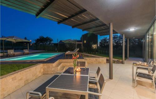 a patio with a table and chairs next to a pool at Villa Caeli in Petehi