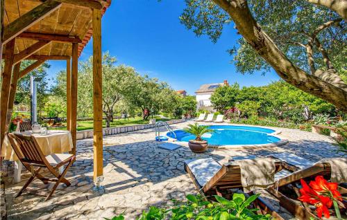 une cour avec une piscine, des chaises et un arbre dans l'établissement Nice Apartment In Mundanije With Wifi, à Mundanije