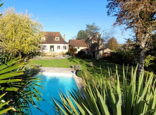 une maison et une piscine dans une cour dans l'établissement Les Charmes de Sarlat - Chambres d'Hotes, à Sarlat-la-Canéda