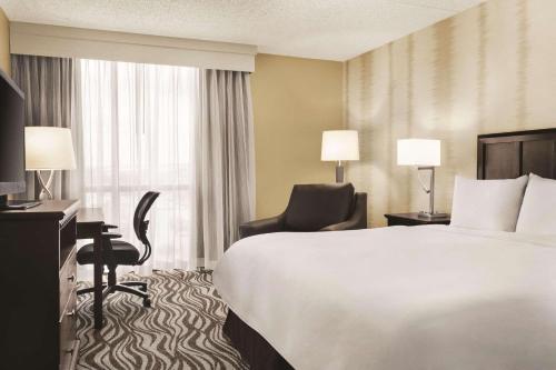 a hotel room with a bed and a chair and a window at Radisson Hotel Fort Worth North-Fossil Creek in Fort Worth