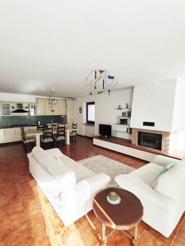 a living room with two white couches and a table at Appartamento Cogno in Esine