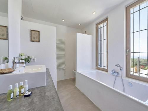 a white bathroom with a tub and a sink at Holiday Home Ibiza near Cala Tarida Beach in Sant Josep