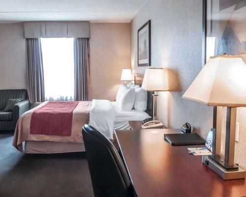 a hotel room with a bed and a desk at Comfort Inn in Mississauga
