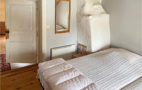 a bedroom with a white bed and a mirror at 4 Bedroom Lovely Home In Lammhult in Lammhult