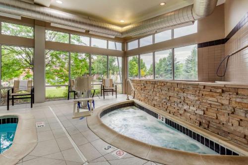 an indoor hot tub in a large room with windows at Cambria Hotel Ft Collins in Fort Collins